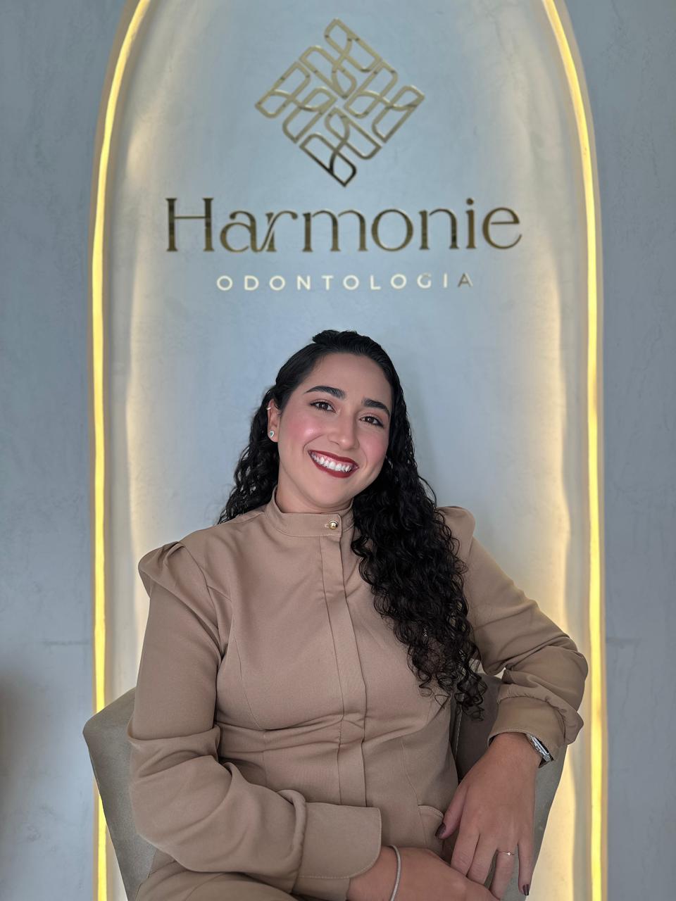 Recepção da Clínica Harmonie com letreiro dourado iluminado